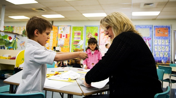 student showing his work to teacher