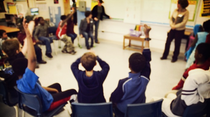 blurred picture of students in chairs in a circle