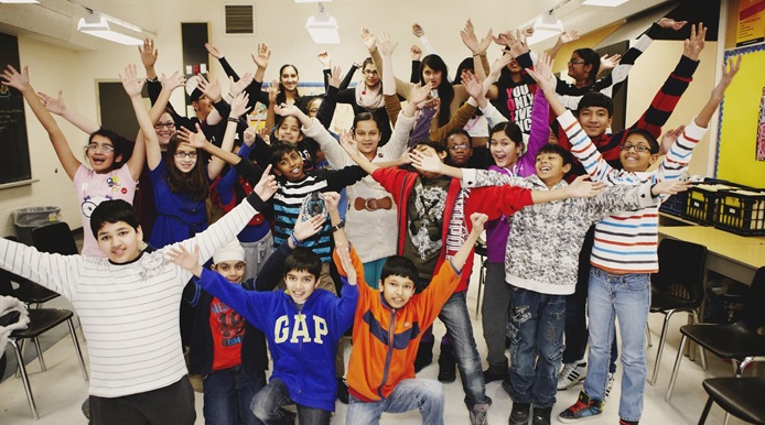 group of students with both hand up and out wide