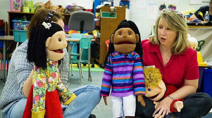 2 teachers with student puppets