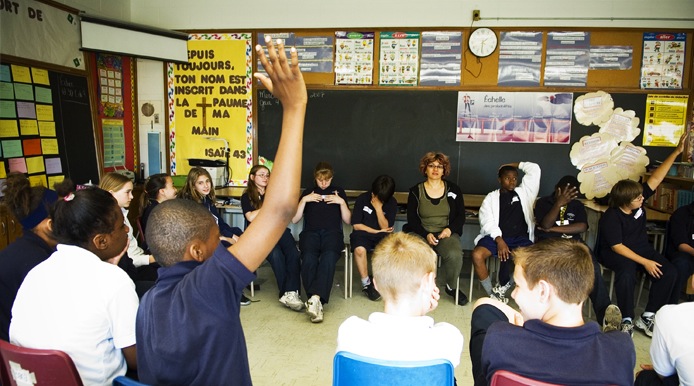 kid raising hand in class