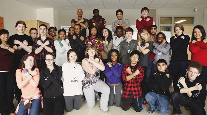 group of people showing they are strong by them all individually making a cross with their arms