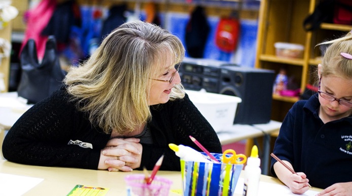 teacher guiding a young student with their school work